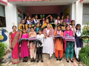  शिक्षण सामग्री वितरित करती हुई समाजसेवी।